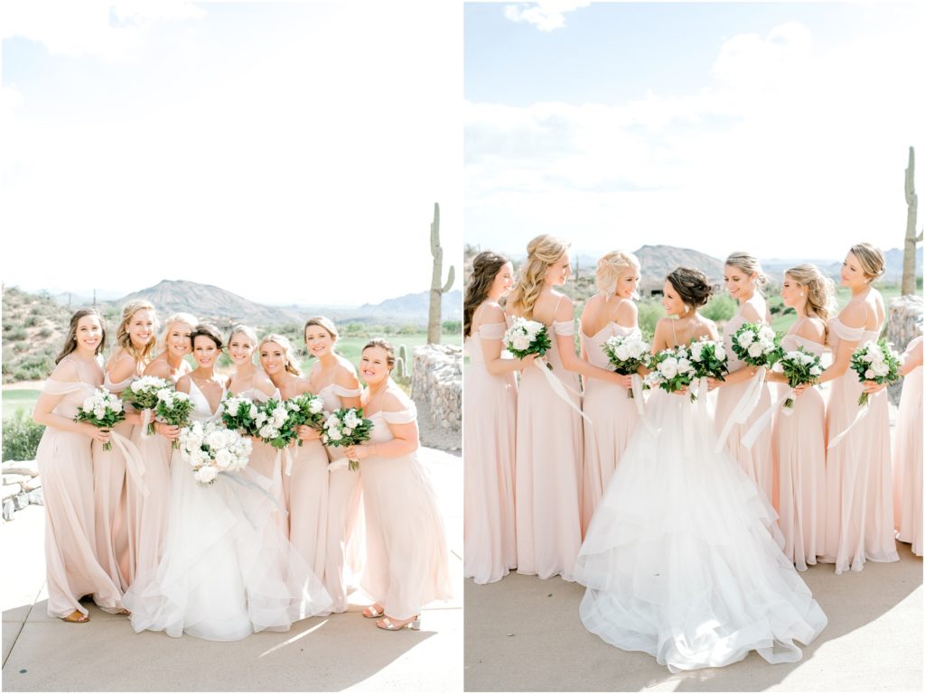 bride with bridesmaids wearing blush dresses and holding bouquets with white roses and greenery